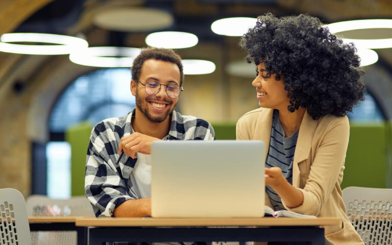 man and woman sat round a laptop