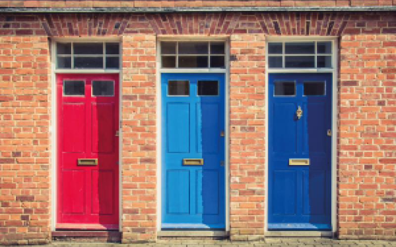 Three house doors in red, light blue and dark blue colours