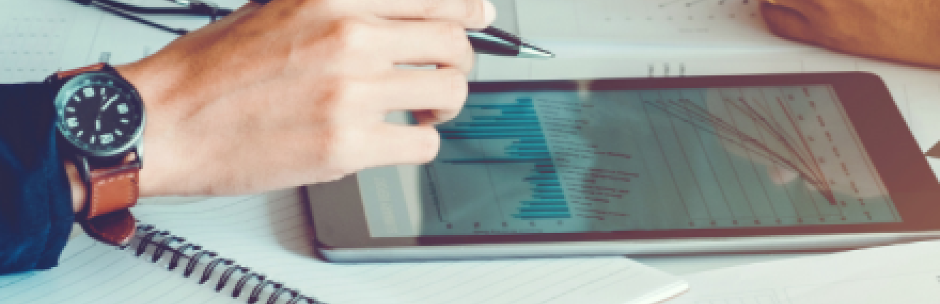 People writing on notes and in notebooks on a desk